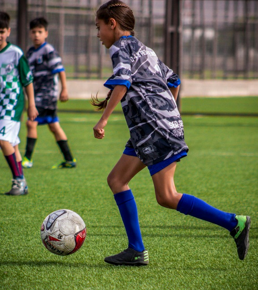 Young players engaged in a dynamic soccer match on a sunny day, showcasing youthful energy and teamwork.